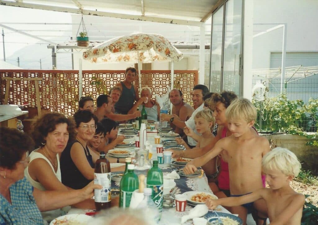 an extended Sicilian family eating traditional Sicilian food outside